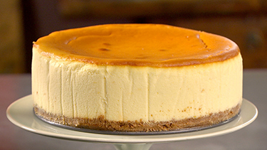 A golden top cheesecake on a white plate