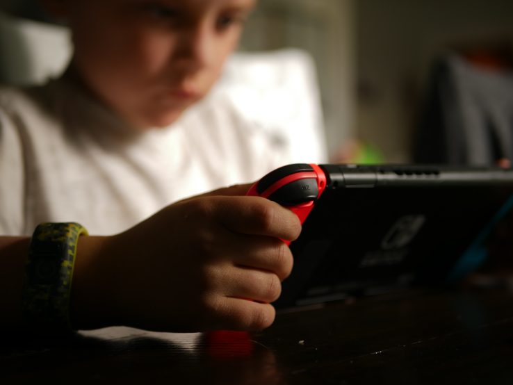 An image of a young child playing with a handheld console.