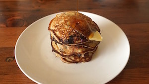 stack of pancakes with pat of butter and maple syrup.