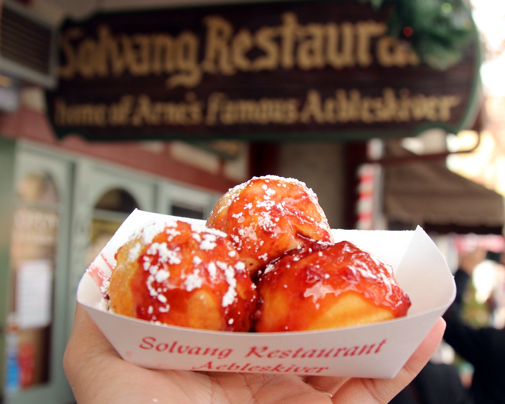 Someone carrying 3 big aebleskivers.
