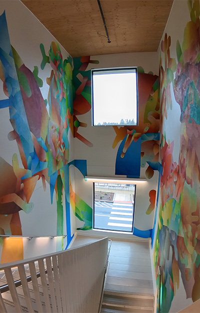 Photo of abstract mural painted across the three walls confining a staircase