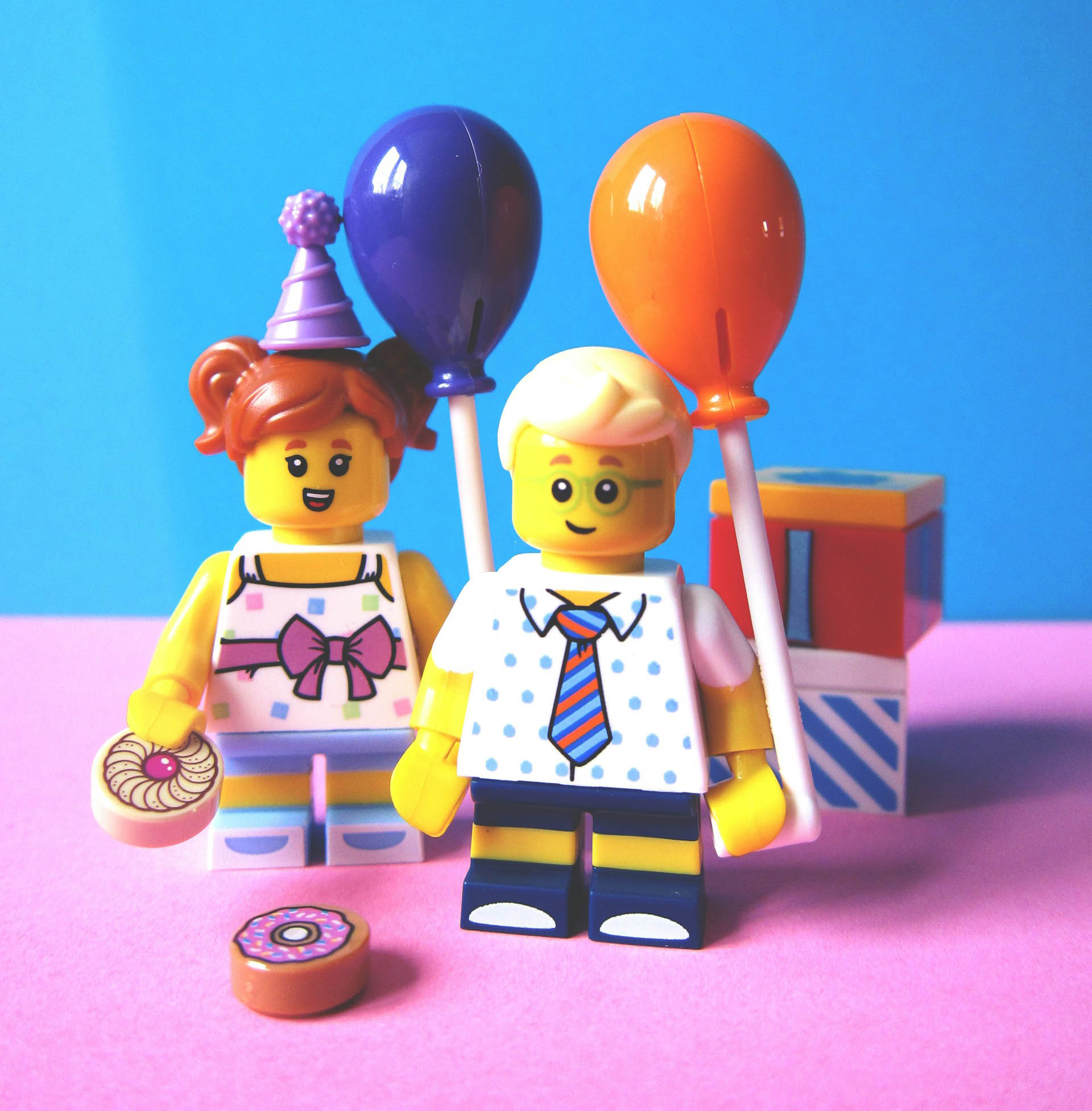 two lego figures holding balloons