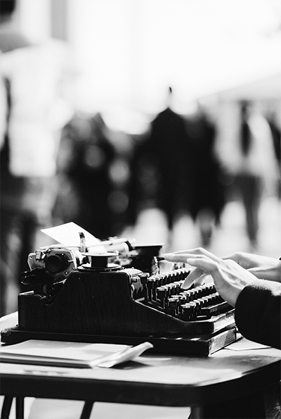 woman typing on typewriter outside