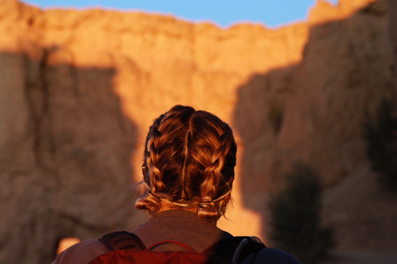 Looking over the shoulders of a hiker during the sunrise at Bryce Canyon.