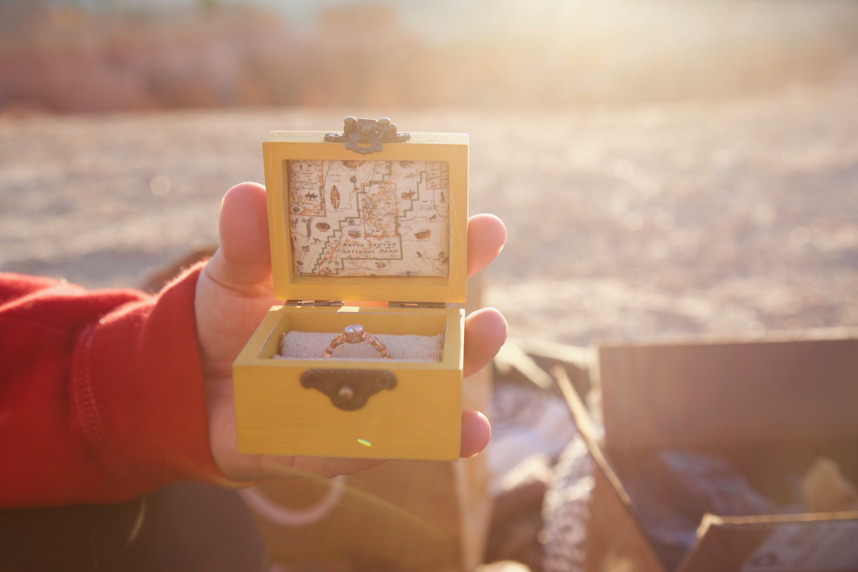 A beautiful rose gold engagement ring sitting in a yellow box.