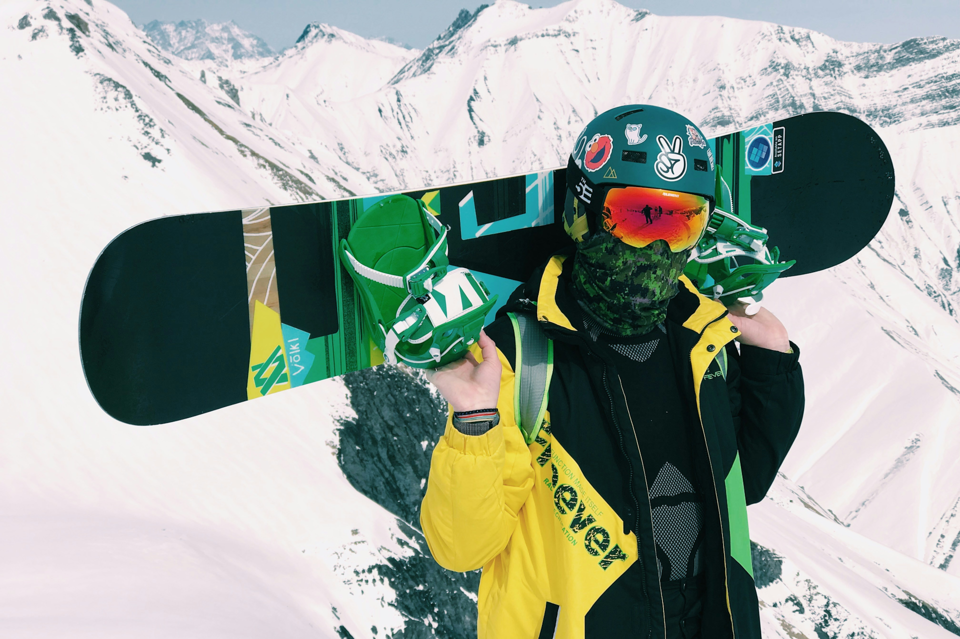 a snowboarder holding their board on their shoulders