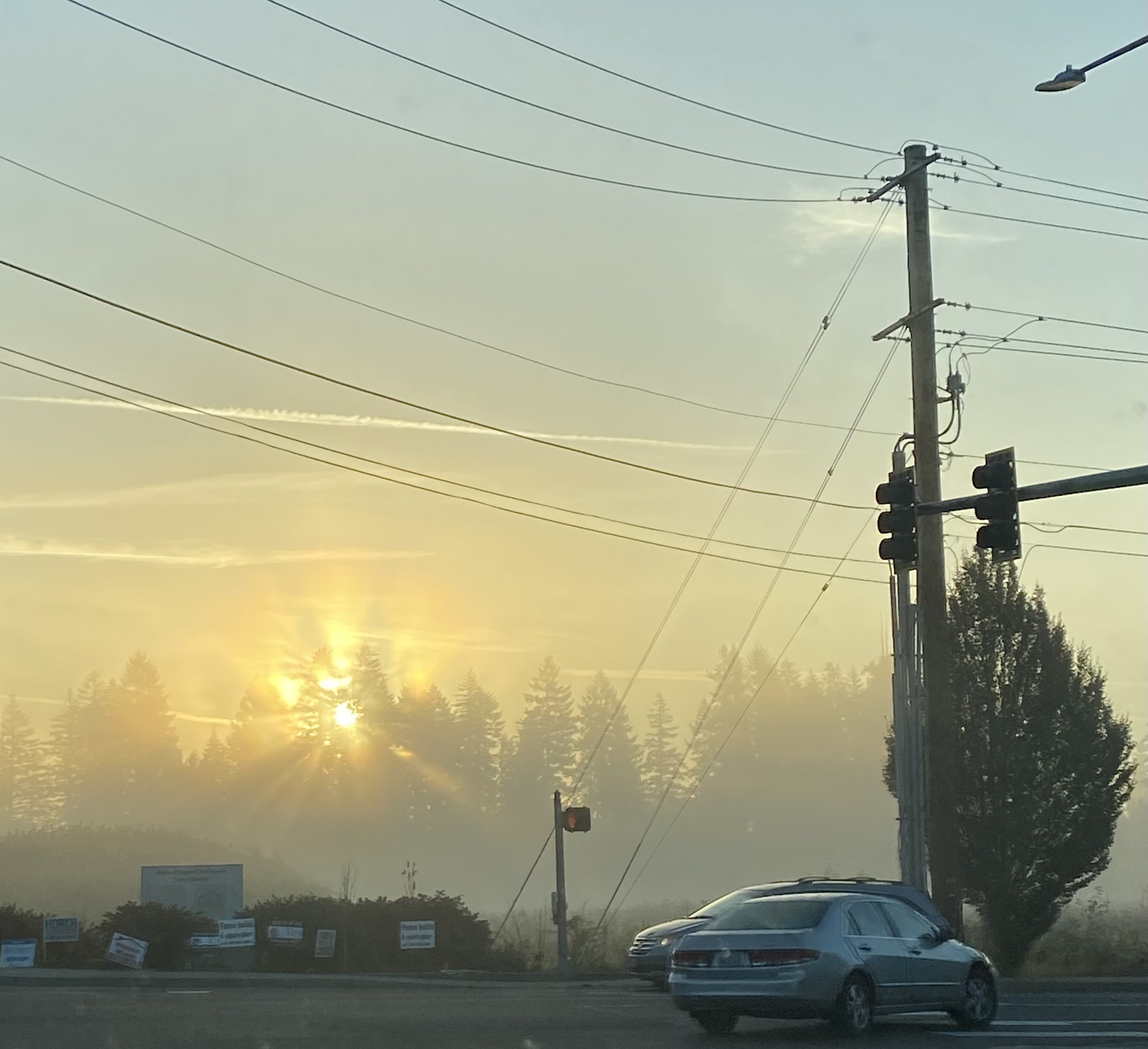 A street at dawn with the golden sun shining through the clouds