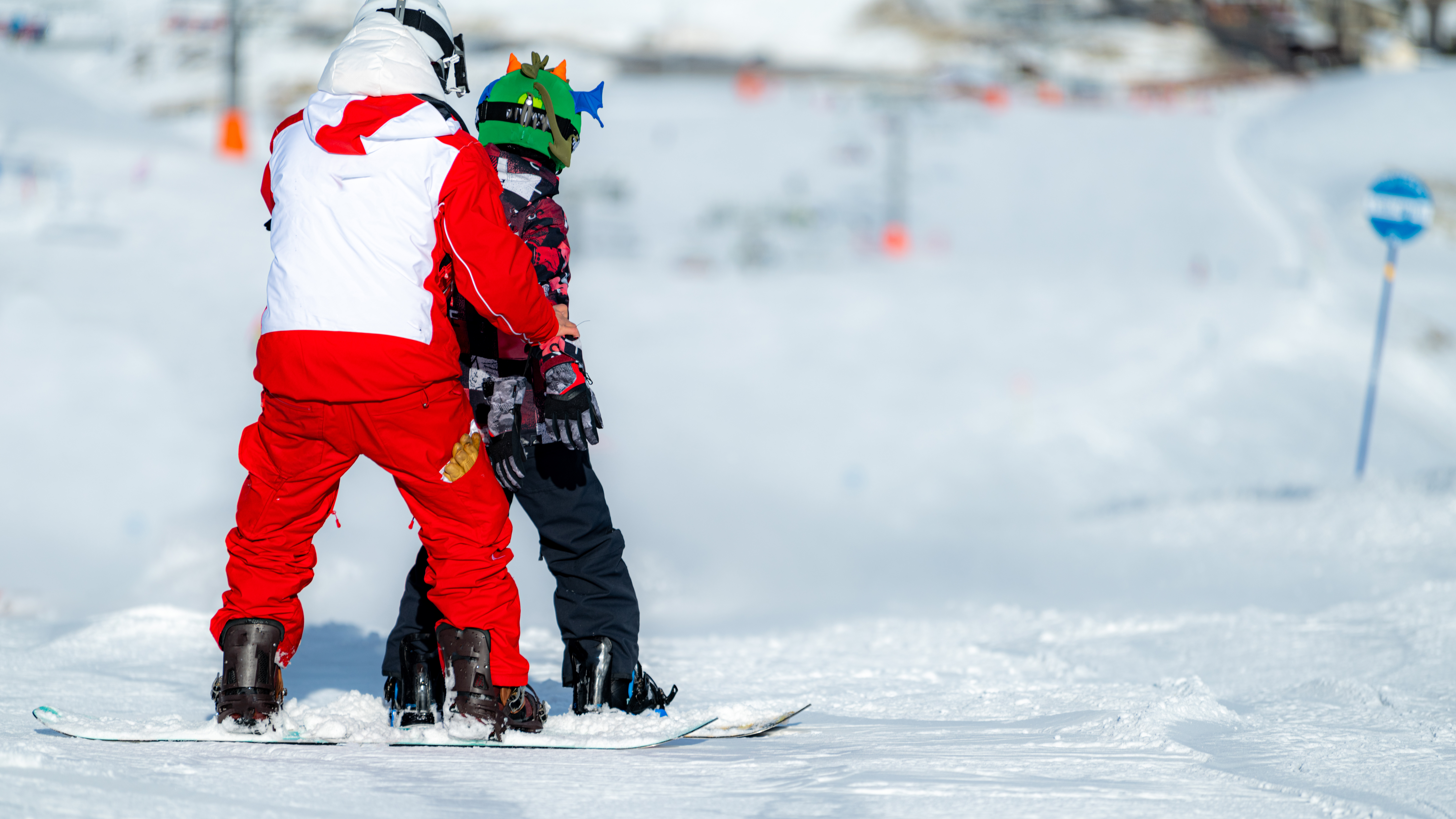 snowboard instructor teaching a kid