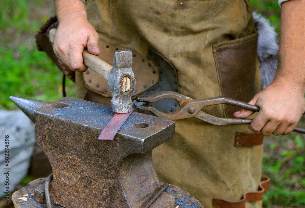 Blacksmith welding together a usable steel billet.