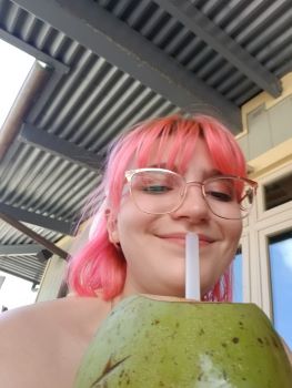 A photo of Kylie drinking from a coconut.