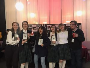 A photo of theater kids holding up awards.