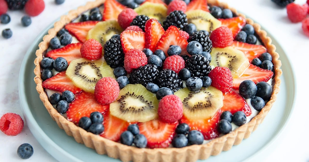 A beautifully presented fruit tart with a variety of fresh fruits on top