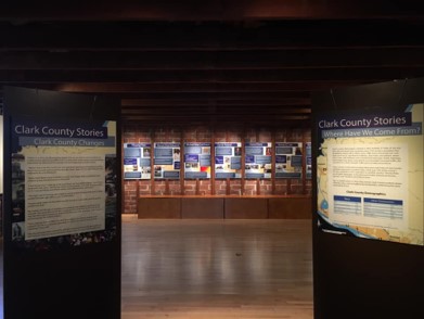 Open room, signage on left and right leading walkway to more signage in background, Clark County Historical Museum Exhibit