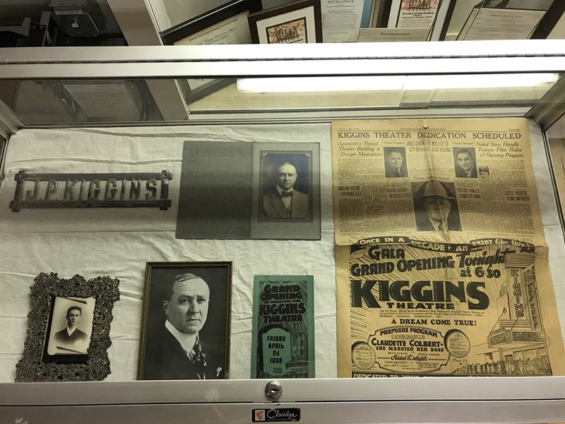Glass display case holding images of individuals & local newspaper pages on white background, Clark County Historical Museum