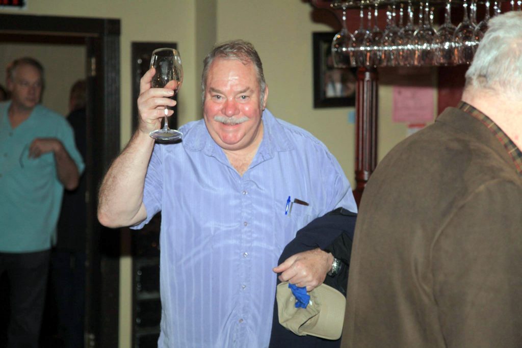 Guest raising his glass towards the camera.