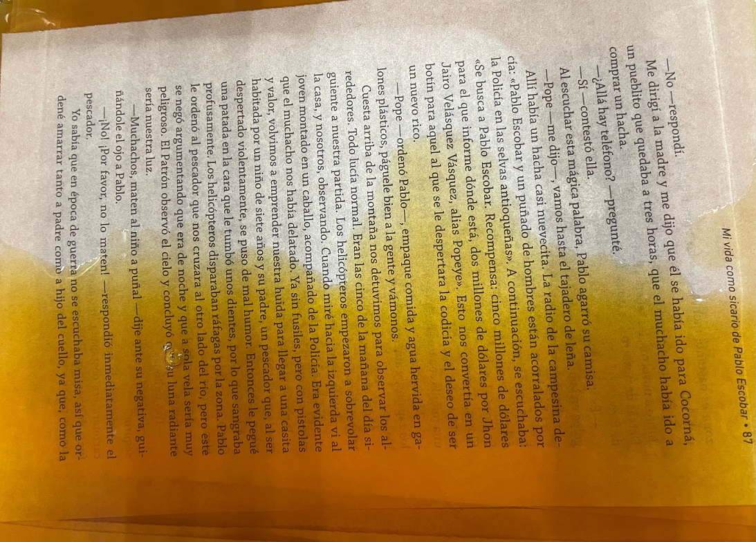 A book page submerged in orange dye