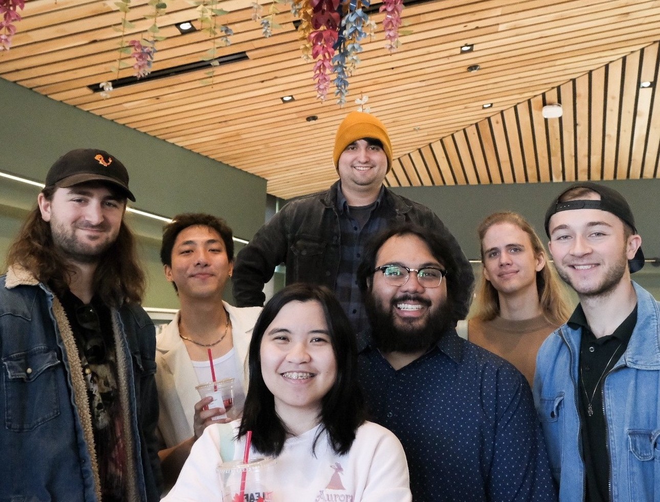 A group of people posing under Phonic Bloom data sculpture at Woodland Community Library