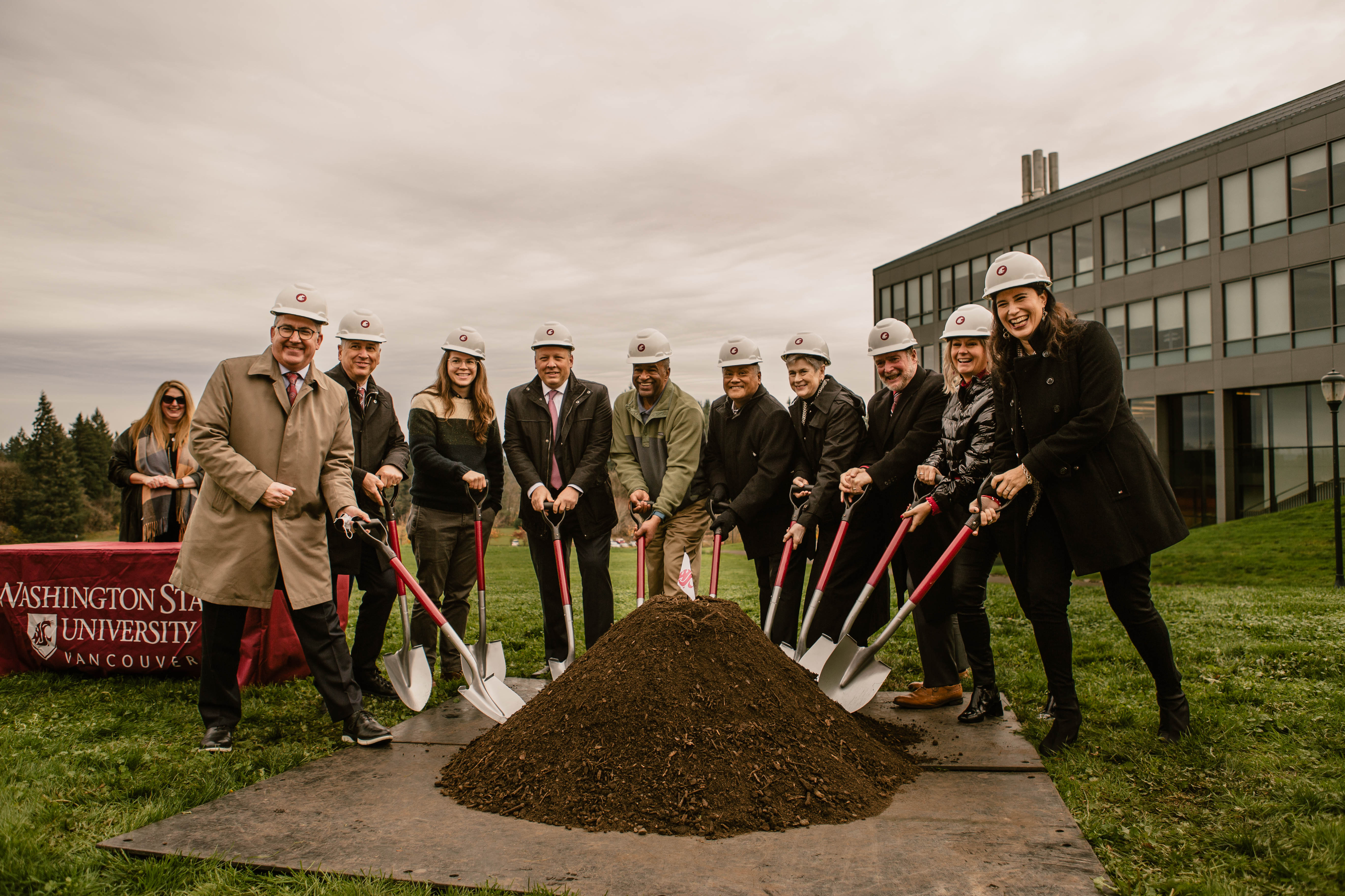 Group of people with shovels and pile of dirt