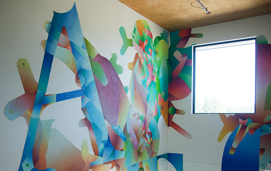 Colorful abstract letters and organic forms painted on stairwell walls with natural light, by Roberto Delgado