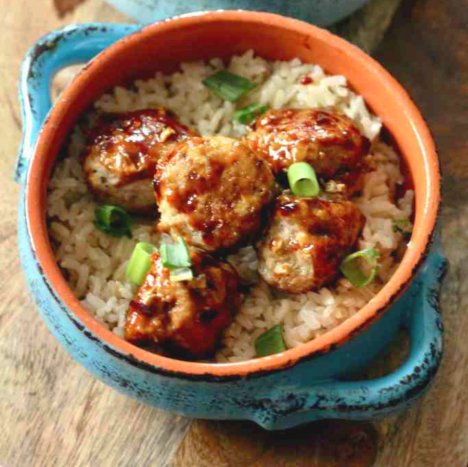 meatballs served over rice in a blue bowl.