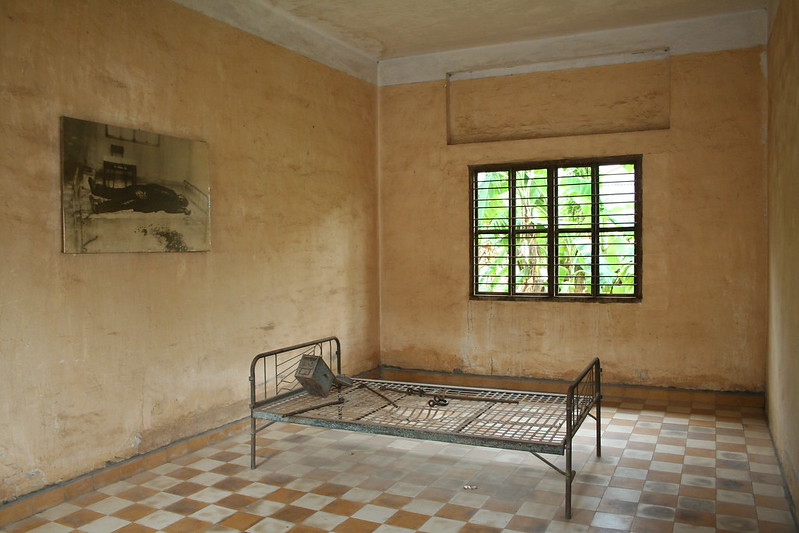 inside one fo the rooms, a bed with torture devices and a picture depicting a prisoner