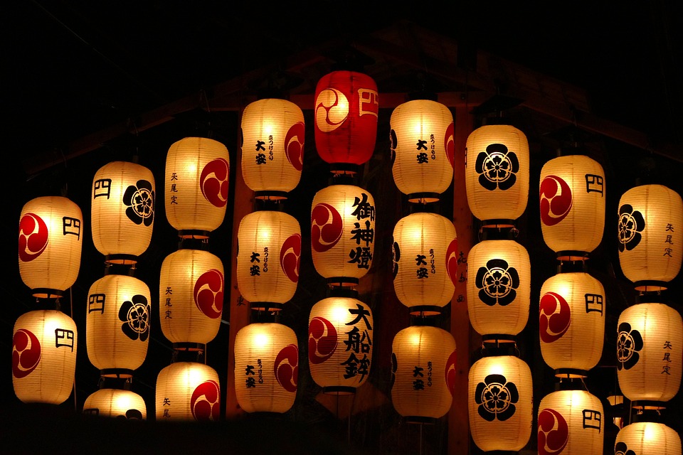an image of several lanterns which are lit up against a dark background during the gion matsuri festival which was taken from pixabay